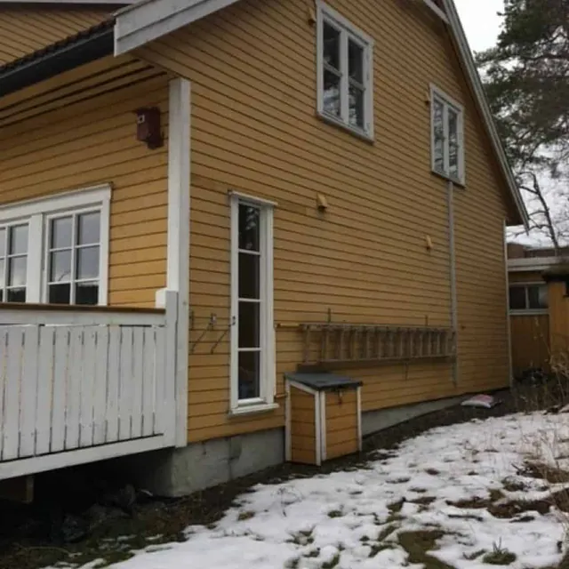 Gult hus før maling om vinteren